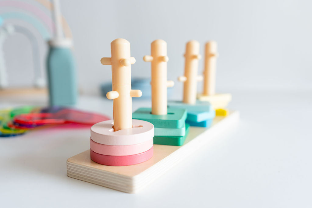 Colorful wooden stacking toy on a light surface with a blurred background